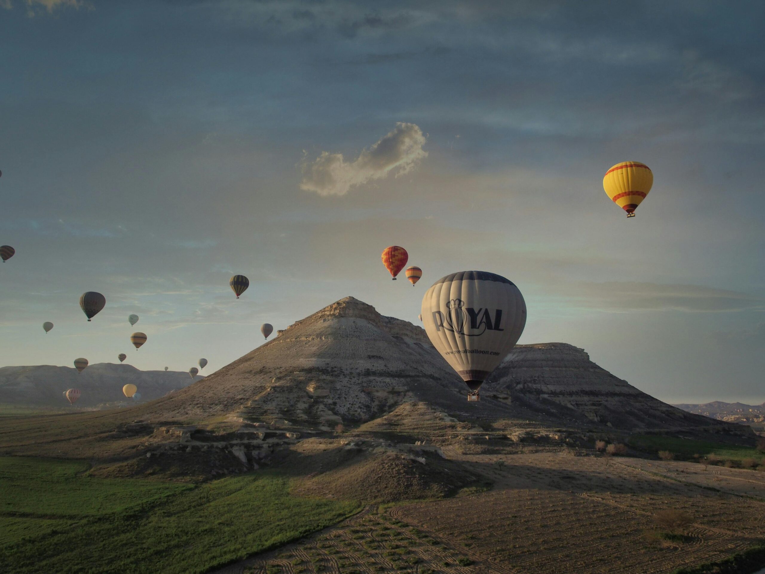 Services A stunning view of hot air balloons soaring above Cappadocia's unique landscape during sunset.